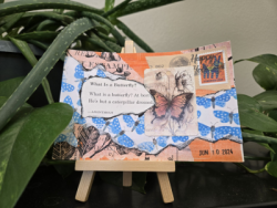 A postcard collage featuring a poem about butterflies, a vintage stamp, and blue butterfly illustrations, displayed on a miniature easel.