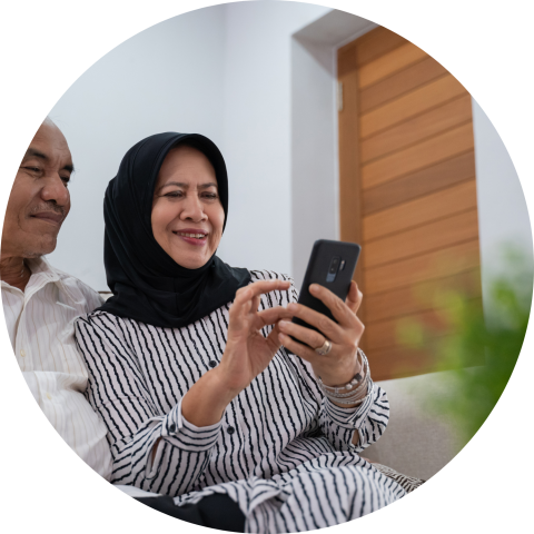 mature couple looking at an iPhone while sitting on a couch
