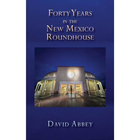 Navy blue book cover with photo of New Mexico Roundhouse building, title and author text that reads "Forty Years in the New Mexico Roundhouse, David Abbey"