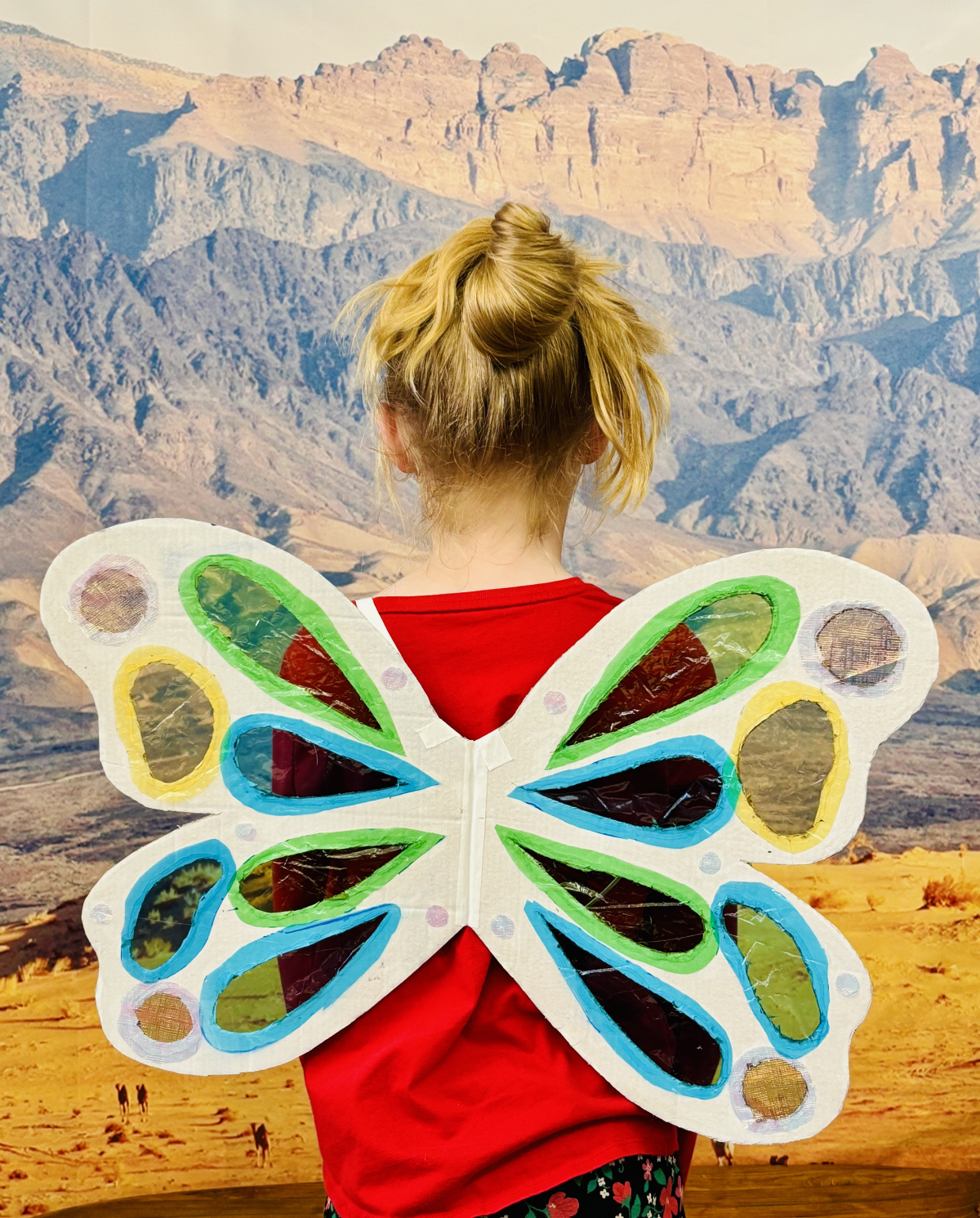 image of a child with butterfly wings on back, with translucent suncatcher holes