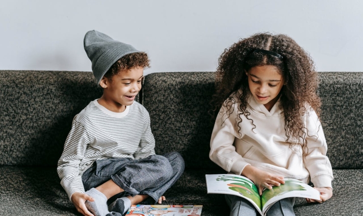 two children reading on a couch
