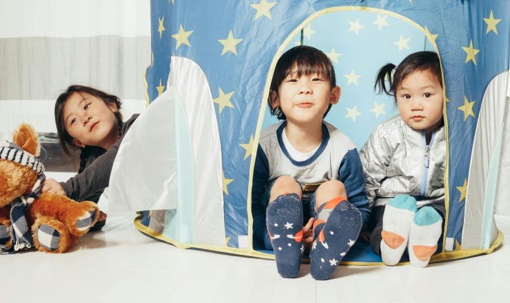 Three Children Sit Inside a Tent
