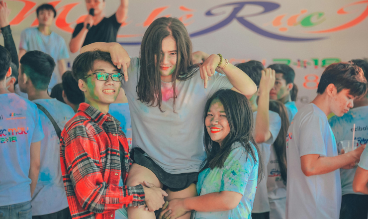 Two Teens Lift Third Teen Up/Covered in Paint